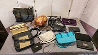 Wide shot showing all twelve handbags and wallets on table
