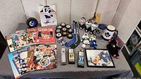 Full lot overview showing pucks, magazines, mini sticks, goalie mask figures, mugs, plush toys, framed photo and pins