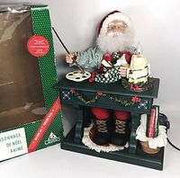 Full view of Santa figurine on desk with candle and palette beside original box