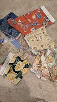 Group of assorted patterned fabric swatches spread on carpet