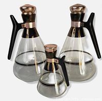 Front view of three carafes showing design, sizes and stoppers