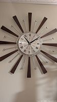 Front view of starburst wall clock showing dial and ray design