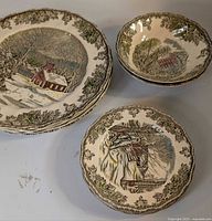 Stack of dinner plates, stack of soup-cereal bowls and stack of salad plates displaying Friendly Village pattern