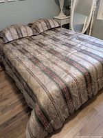 Comforter and two shams displayed on queen bed