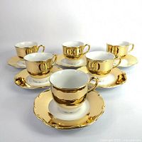 Full set of 6 gold demitasse cups with saucers displayed