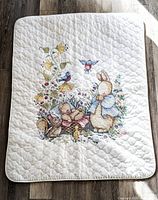Full view of ivory quilt showing complete embroidered Beatrix Potter scene