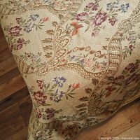 Close view of jacquard fabric showing gold ground and woven floral pattern