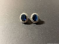 front view of both earrings showing blue stones and halo