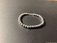 Full view of silver-tone beaded bracelet laid flat