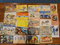 Full grid view of all postcards laid out on wooden surface