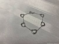 Full view of bracelet showing five heart links and clasp