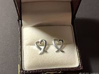 Front view of heart-shaped stud earrings in box