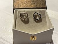 pair of silver open-heart stud earrings in display box