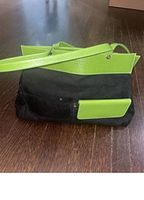 Full view of handbag exterior showing black suede body and green leather trim