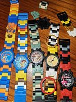 Group shot of five LEGO watches, spare links visible