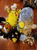 Group photo of all plush toys laid out on wooden floor