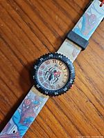 Watch face close-up showing dial, bezel and strap print