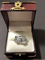 Ring displayed in open presentation box, front view showing stone arrangement