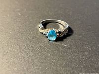 Top view showing oval blue center stone and pavé shoulders