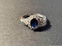 Top view showing oval blue center stone and clear accents