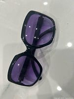 Front view showing black frame and purple lenses