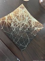 Front view showing brown copper tones and silver swirl design