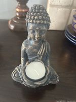 Front view of Buddha tealight holder with candle