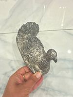silver-tone metal turkey figurine front side