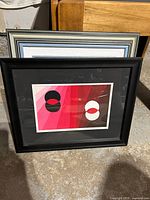 Abstract painting with red gradient and circular motifs in black frame