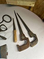 Three narrow-blade saws and portions of other tools