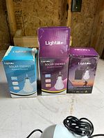 Three LightMe Solar Energy bulb kit boxes displayed upright