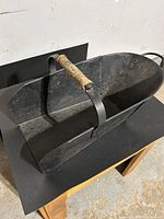 Top angle showing entire coal shuttle, wooden center handle, metal construction