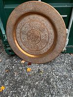Full view of large copper tray leaning on container