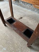 lower shelf with two square black plastic drip trays in wood base