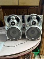 Front view of both JVC speakers side by side showing grills and drivers