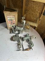 Overall lot view showing two meat grinders, sausage maker, funnel, and box