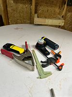 Group view of clamps, plastic caliper, suction device and tools on table
