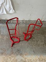 Pair of red metal saddle racks standing on floor