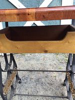 Close view of wood basket beneath table top and cast iron legs