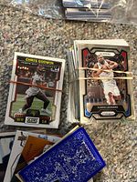 Stacks of trading cards with Chris Godwin Score card and Kawhi Leonard Prizm card visible