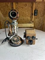 Candlestick telephone and wooden phone-shaped pencil sharpener side by side