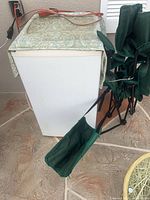 Green folding chairs leaning against white appliance