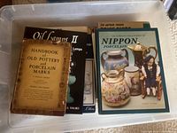 Plastic bin filled with various antique reference books, front view