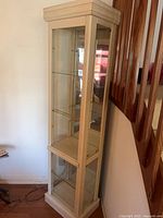 Front view of light wood tower curio cabinet