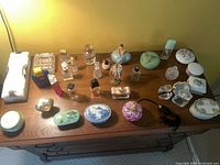 Overall view of dresser top showing perfume bottles, ceramic boxes, atomizer and clutch