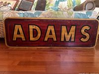 Front view of red and gold Adams sign
