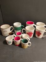 All twelve mugs arranged showing fronts and interiors