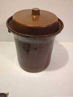 Full view of brown glazed stoneware crock with lid