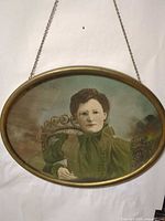 Full view of oval framed portrait with chain hanger