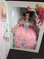 Doll inside open display box showing gown and accessories